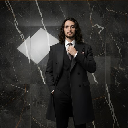 CEO تصویری ازl مدیر اجرایی شرکت فاخرعجمان در کت شلوار و پالتو در دیوار مرمری مشکی